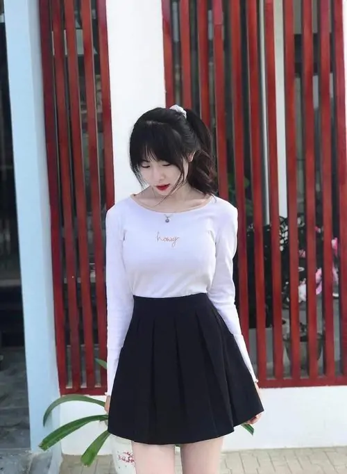 Bối cảnh quán cà phê Hàn Quốc làm nổi bật cô gái tóc dài mặc váy ngắn pastel, tay cầm ly và mỉm cười dịu dàng
