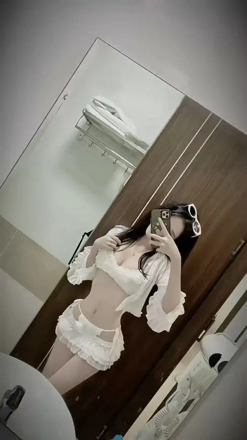 Mũ lưỡi trai trắng đi cùng chân váy xếp ly tạo phong cách đường phố, cô gái đứng nghiêng với ánh mắt tự nhiên