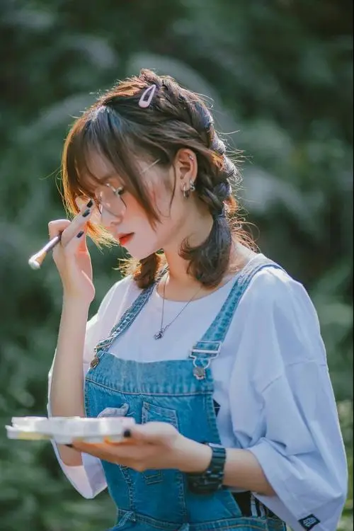 Dưới tán cây xanh, ảnh nghệ thuật phái đẹp ghi lại cô gái mặc yếm xanh cầm bát nhỏ, tóc buộc hai bên đáng yêu