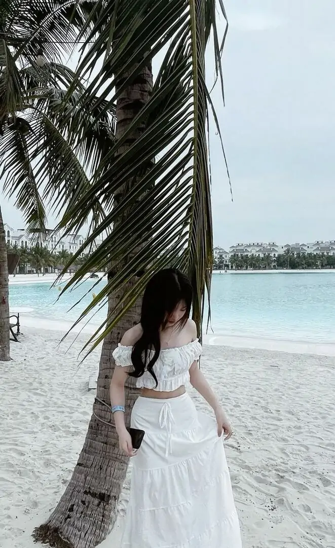 Tạo dáng đứng dưới hàng dừa nhìn xuống tự nhiên