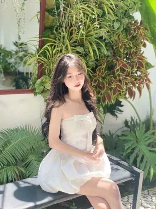 Khung hình studio ghi lại ảnh cô gái váy ngắn tôn dáng, nền sáng sạch và màu trang phục hài hòa giúp gương mặt nổi bật